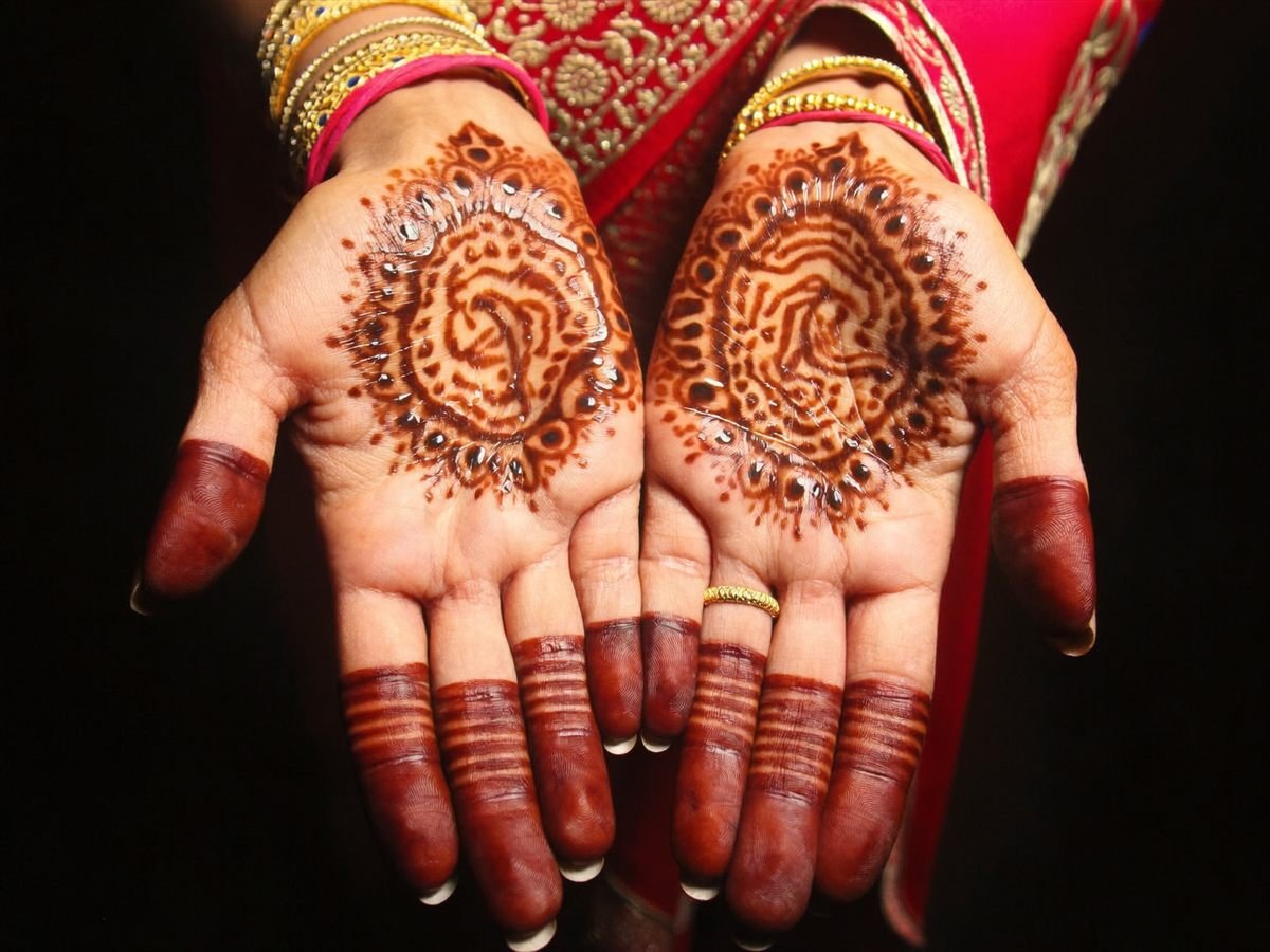 Close-up of bridal henna on both hands, dark stain with fine paisley detail